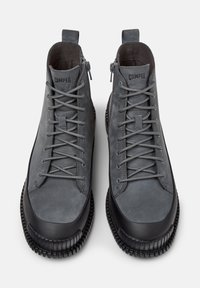 Stivaletti grigi alla caviglia dal design elegante, con lacci e cerniere, su sfondo bianco, che mettono in evidenza uno stile moderno e urbano.