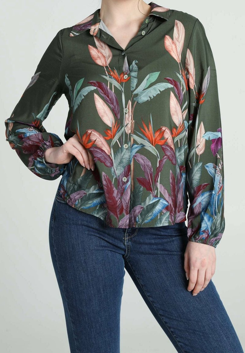 Camicia a maniche lunghe con bottoni di colore verde scuro, decorata con una stampa di foglie tropicali colorate. Presenta un orlo arrotondato e polsini con bottoni per un fit rilassato.