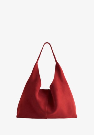 Red suede tote bag with a wide, deep opening and a single elongated strap, featuring a smooth texture and a minimalistic design.