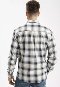 Męska koszula w kratę w kolorach białym, granatowym i jasnoniebieskim. Kołnierzyk zapinany na guziki, długie rękawy oraz detal w postaci plisy z tyłu. Miękka, bawełniana tekstura.