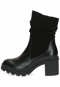 Botines negros con un puño de ante arrugado, cuerpo de cuero suave, suela de goma gruesa y tacón cuadrado, con un patrón texturizado.