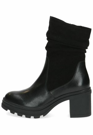 Botines negros con un puño de ante arrugado, cuerpo de cuero suave, suela de goma gruesa y tacón cuadrado, con un patrón texturizado.