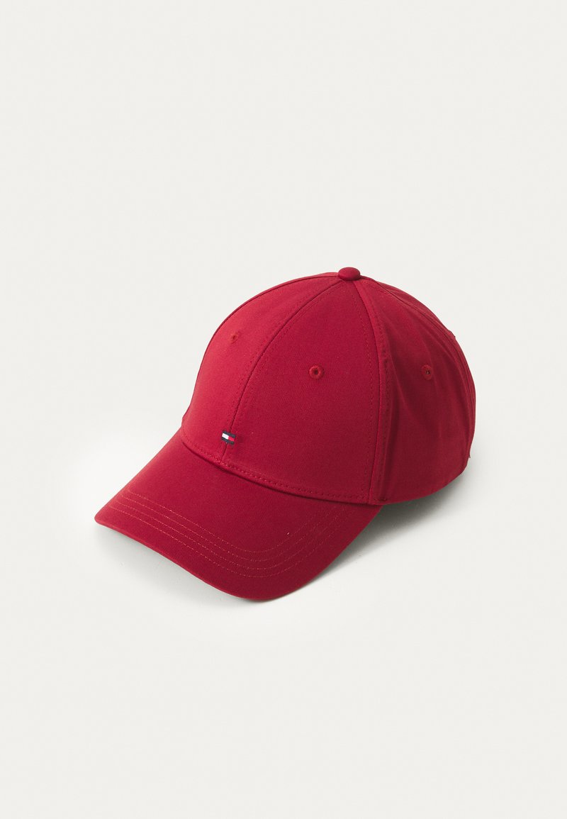 Red cotton baseball cap with a curved brim, six panels, eyelets for ventilation, and a small embroidered logo on the front.