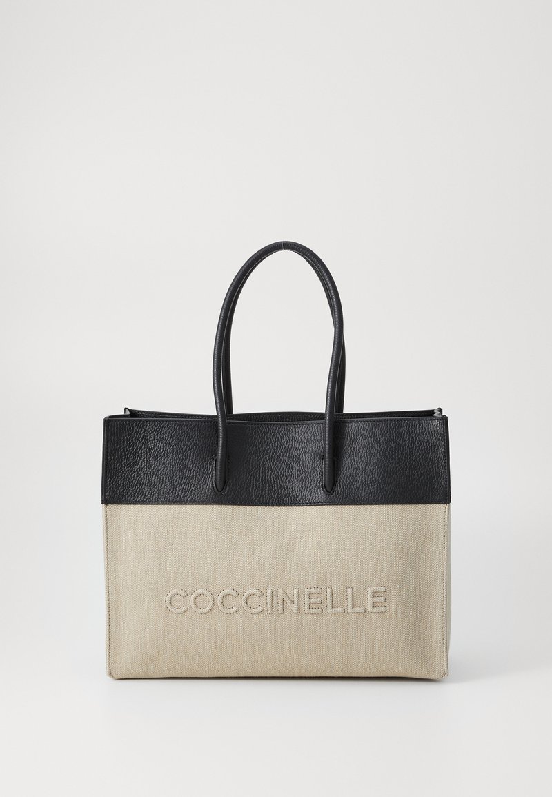 Borsa a tracolla con parte superiore in pelle nera texturizzata e parte inferiore in canvas beige, con il testo in rilievo "COCCINELLE" sul fronte e due manici.