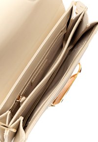 Borsa a tracolla in pelle beige con più scomparti, dettagli in metallo dorato e texture liscia. L'interno presenta sezioni divise e una tasca con zip.