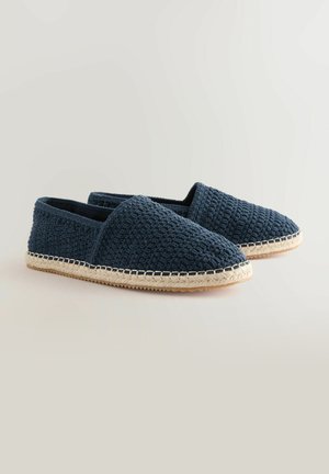 Espadrillas intrecciate blu navy con una tomaia testurizzata, punta rotonda e dettagli in corda naturale lungo la suola, caratterizzate da un profilo piatto.