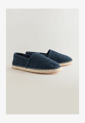 Espadrillas intrecciate blu navy con una tomaia testurizzata, punta rotonda e dettagli in corda naturale lungo la suola, caratterizzate da un profilo piatto.