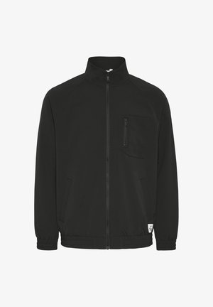 Juodas zip-up džemperis su aukštu apykakle, šoninėmis kišenėmis ir krūtine kišenę su užtrauktuku. Savybės: elastingi rankogaliai ir laisvas kirpimas.