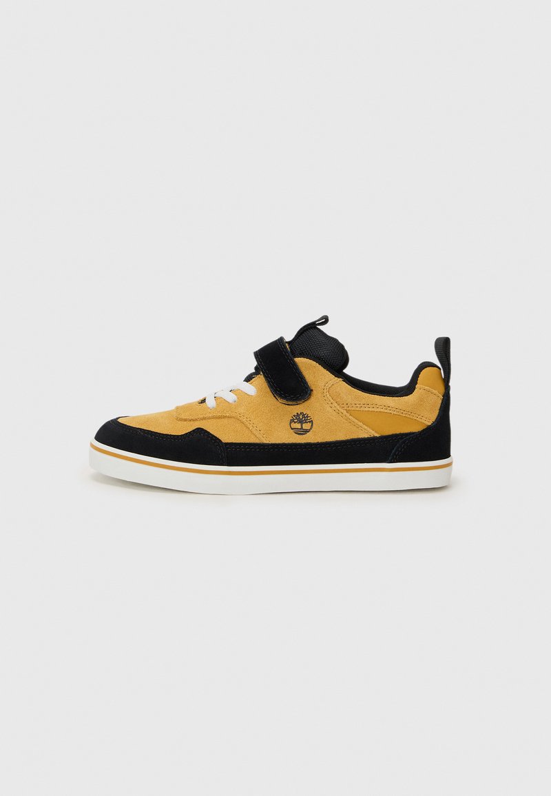 Baskets en daim avec accents noirs, tige jaune, lacets blancs, sangle Velcro et détails texturés ; logo sur le côté et semelle contrastante.