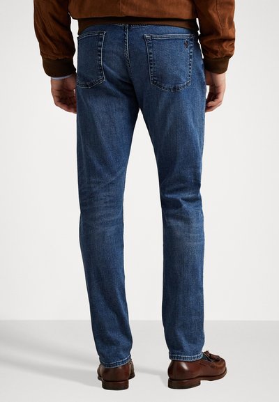 Meeste sinised teksapüksid, slim fit lõikega, millel on kaks tagataskut ja kerge kulumine. Kantud pruuni nahkjalaga.