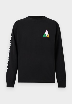 Čierna košeľa s dlhým rukávom s geometrickým trojfarebným trojuholníkovým logom na hrudi a bielym vertikálnym nápisom na ľavom rukáve.