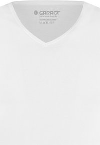 Witte V-hals T-shirt, gemaakt van 90% biologisch katoen en 10% elastaan. Gladde textuur met een label waarop het merk en de verzorgingsinstructies staan.