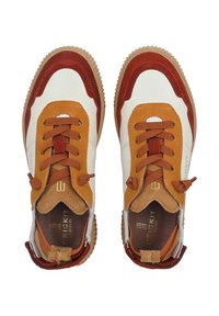 Buty sportowe w połączeniu białego, pomarańczowego i czerwonego zamszu z brązowymi gumowymi podeszwami i płaskimi sznurowadłami. Widoczne akcentowane przeszycia i oznakowanie.