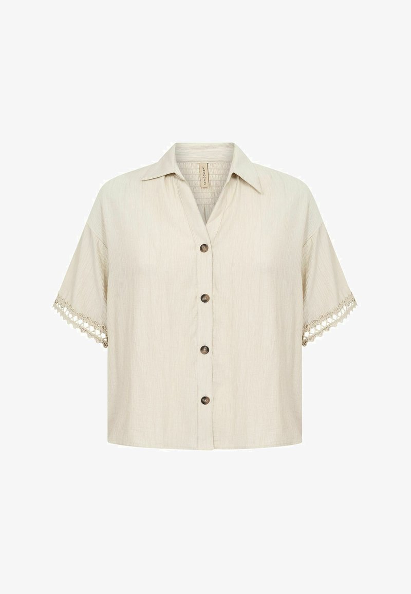 Chemise beige à manches courtes avec col et détails en dentelle sur les manches, en tissu texturé.