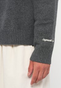 Maglione grigio a coste con orlo e polsini, realizzato in morbido tessuto con dettaglio ricamato "Originals" sulla manica.