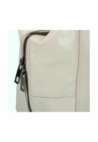 Borsa in pelle vegana color crema con superficie texturizzata, dotata di una zip laterale e dettagli cuciti.