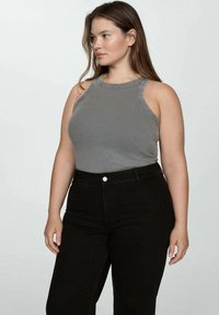 Gray ribbed tank top with a high neckline and wide armholes, paired with high-waisted black jeans featuring a front button closure.