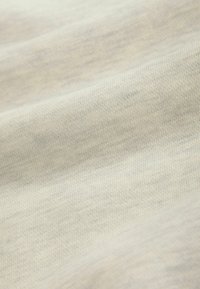 Light grey fabric with a smooth texture, showing fine ribbing and subtle variations in shading, folded to reveal soft draping.