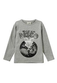 Svietlošedá blúzka s dlhými rukávmi, na ktorej sa nachádza čierno-biely grafický motív diskoguľe s veľkou bielou mašľou a trblietavým čiernym textom s nápisom „Stretnime sa na DISCO.“