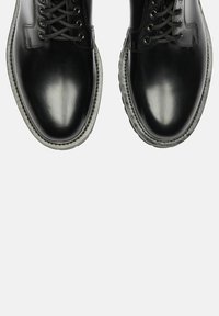 Stivali alla caviglia in pelle nera con finitura liscia, punta rotonda e design con lacci. Presentano una suola texturizzata e cuciture in contrasto.