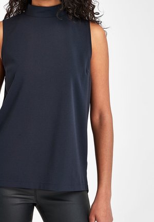 Top sans manches bleu marine avec un col haut, fabriqué en tissu doux. Design simple avec une coupe droite et sans motifs visibles ni détails matériels.