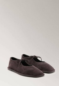 Zapatos de ante gris con punta redondeada, cordones en la parte delantera y un perfil bajo. Textura suave y diseño sencillo. Sin patrones o acentos visibles.