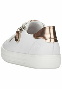 Baskets blanches avec un dessus en cuir lisse, présentant un accent en rose gold métallique au talon et une semelle en caoutchouc blanc texturé.