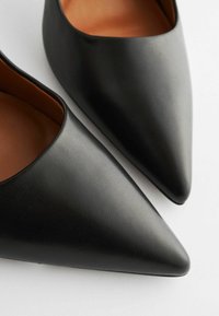 Scarpe nere con punta a punta in ecopelle testurizzata, con una morbida fodera interna e un design elegante e minimalista.