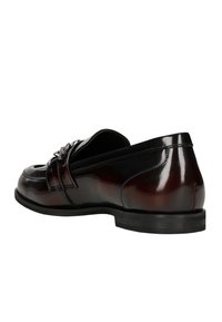 Mocassino in pelle marrone con una finitura lucida, caratterizzato da dettagli cuciti e una striscia decorativa lungo il collo del piede. Suola nera bassa.