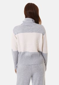 Maglione a righe grigio e crema con colletto alto, orlo a coste e texture morbida, progettato per una vestibilità rilassata.