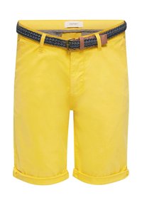 Shorts jaunes arrivant aux genoux avec revers roulés et une ceinture tressée foncée insérée dans les passants, étiquetée Esprit à l'intérieur de la ceinture.