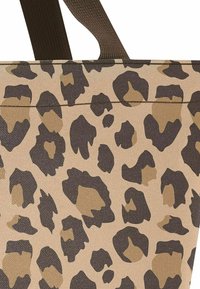 Leopard-print tote bag in beige and brown, featuring a textured fabric with dark brown spots and solid brown straps.