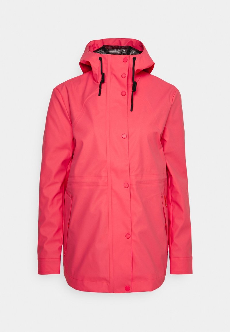 Veste imperméable rose vif pour femme avec capuche, cordons noirs, fermeture par pressions devant et poches latérales.