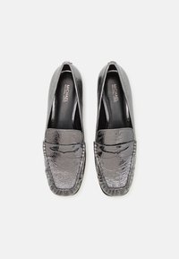 Zwarte leren loafers met een gestructureerde afwerking, ronde neus en decoratieve stiksels op de instap. Merkenlogo zichtbaar op de binnenzool.
