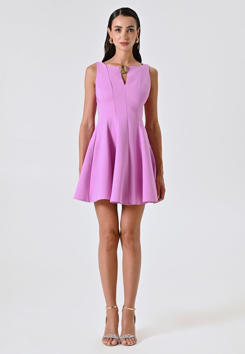 Robe sans manches rose avec un buste cintré et une jupe évasée; présente un décolleté en trou de serrure et un accent circulaire au niveau de la poitrine.