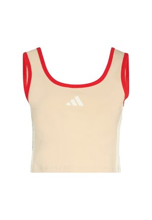 Béžový krátký top bez rukávů s červeným lemem, s bílým logem na přední straně. Tkanina vypadá pružná a hladká, s přiléhavým střihem.