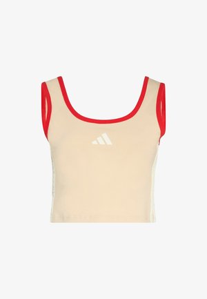 Beige cropped tank top with red trim, featuring a white logo on the front. Fabric appears stretchy and smooth, with a fitted design.