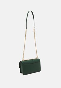 Zelená strukturovaná kabelka s texturou, která má zlatý řetězový popruh a hladký kožený horní úchop.
