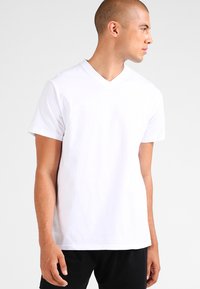 White v-neck t-shirt made of cotton, featuring short sleeves and a relaxed fit. Smooth texture with no patterns or accents.