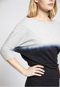 Grauer und schwarzer Strickpullover mit einem Ombre-Effekt, weitem Boot-Ausschnitt, Dreiviertelärmeln und einer weichen Textur.