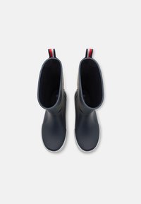 Bottes de pluie en caoutchouc marine avec une finition lisse, semelles blanches, et des tirants rayés rouges et blancs en haut. Conçues pour un enfilage facile et le confort.