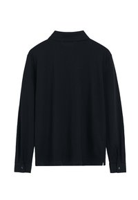 Chemise noire à manches longues avec col, munie de poignets boutonnés et de fentes sur les côtés. Fabriquée dans un tissu doux et lisse avec un minimum de détails.