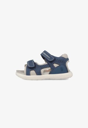 Sandalo aperto per bambini, blu e beige, con due cinturini regolabili in Velcro e suola bianca flessibile.