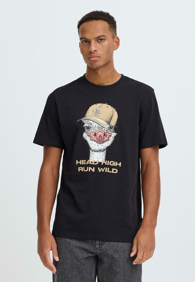Sort bomulds-T-shirt med et strudsemotiv iført en beige kasket, med teksten "HEAD HIGH RUN WILD" i beige under designet.