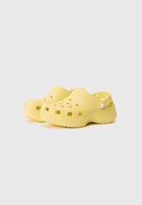 Yellow clogs made of lightweight material, featuring ventilation holes, a textured strap, and a rounded design with a raised sole.