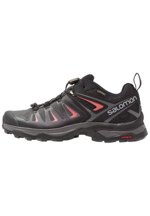 Czarne i ciemnoszare buty trekkingowe Salomon z czerwonymi akcentami, metką Gore-Tex, systemem szybkiego sznurowania i wytrzymałą podeszwą z technologią Contagrip.