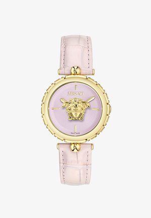 Hodinky Versace s růžovým texturovaným ciferníkem, zlatým emblemem Medusa, zlatým pouzdrem a světlým růžovým koženým páskem s krokodýlím vzorem. Švýcarská výroba.