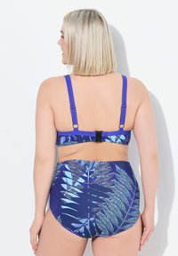 Bikini s vysokým pasem v modré barvě s tropickým vzorem listů. Nastavitelné ramínka a pevný pás s sponou na zadní straně. Hladký povrch.
