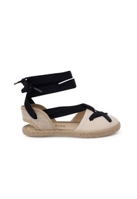 Sandalo espadrille con suola in juta intrecciata, parte superiore in tela beige e doppi cinturini neri in tessuto per il supporto della caviglia con dettaglio a fiocco.