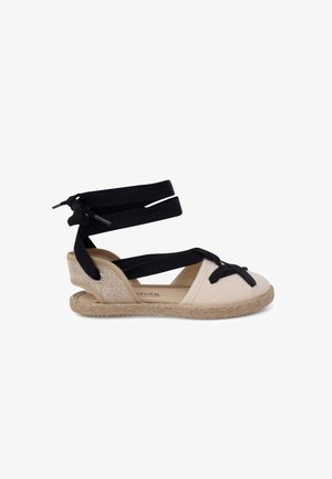 Espadrille sandaal met een geweven jute zool, een beige canvas bovenkant en dubbele zwarte stoffen banden voor enkelondersteuning met een strikdetail.
